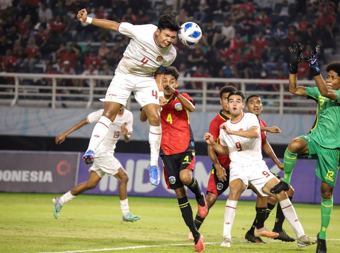 Pesepak bola Timnas Indonesia Kadek Arel Priyatna (kiri) menyundul bola dihadang penjaga gawang Timnas Timor Leste Alexandre Oscar Lima (kanan) dalam pertandingan penyisihan Grup A Piala ASEAN U-19 Boys Championship atau AFF U-19 di Stadion Gelora Bung Tomo, Surabaya, Jawa Timur, Selasa (23/7/2024). ANTARA FOTO/Rizal Hanafi/sgd/nym.