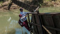Salah satu sling baja penahan besi jembatan dalam keadaan putus menyisakan pijakan besi yang menggantung. Meski begitu, warga hingga pelajar terpaksa bergelantungan saat melintasi jembatan tersebut.