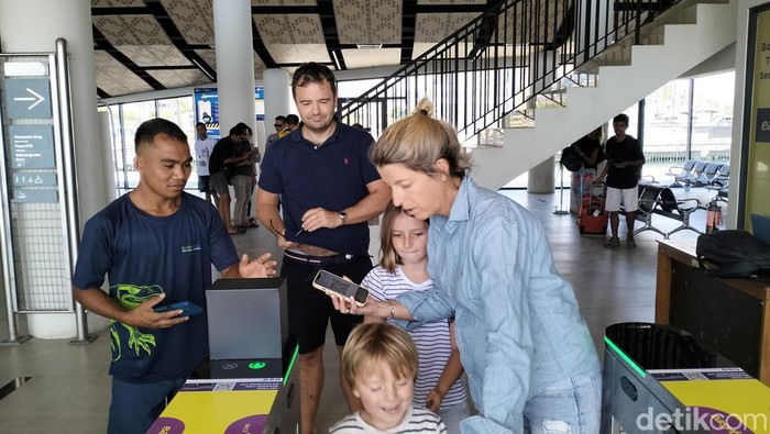 Sejumlah wisatawan mancanegara melakukan scan barcode boarding pass sebelum naik kapal wisata di pelabuhan Marina Waterfront Labuan Bajo, Selasa (23/7/2024). (Ambrosius Ardin/detikBali)