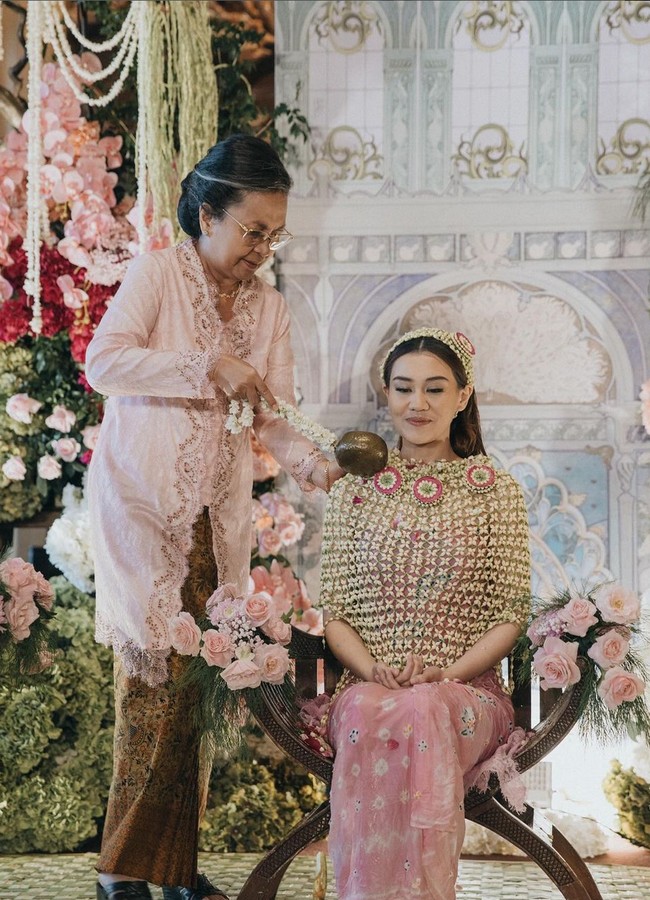 Senyuman selalu menghiasi wajah Aaliyah selama prosesi siraman. putri mendiang Adjie Massaid dan Reza Artamevia ini tampak memakai jubah ronce melati dipadu batik jumputan warna pink. Foto: Instagram/@aaliyah.massaid @leoafandi_
