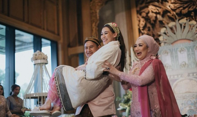 Mudjie Massaid, adik dari Adjie Massaid, menggantikan sang ayah untuk menggendong keponakannya itu. Momen manis itu sontak memunculkan rasa haru namun bahagia. Foto: Instagram/@aaliyah.massaid @leoafandi_