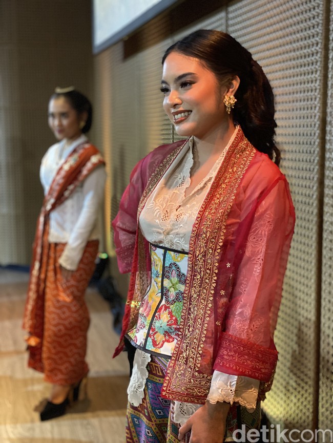 Ia memakai kebaya Timor dengan mengusung gaya layering yang kekininan. Padanan kebaya putih dan luaran berwarna merah diberi twist modern berupa korset batik motif floral berwarna cerah. (Foto: Daniel Ngantung/detikcom)