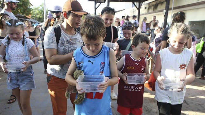 Antusias Bule Ikut Lepaskan Tukik di Pantai Bali Tourists prepare to release baby sea turtles at Kuta beach, Bali, Indonesia on Tuesday, July 23, 2024. About three hundred newly hatched Lekang turtles were released during a campaign to save the endangered sea turtle. (AP Photo/Firdia Lisnawati)