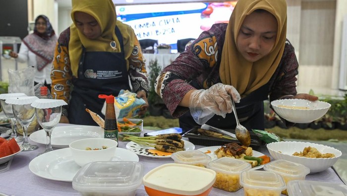 Dua peserta menyiapkan kreasi makanan bergizi saat Lomba Cipta Menu Makanan Pangan Beragam, Bergizi, Seimbang, dan Aman (B2SA) di Gedung Serbaguna, Kabupaten Tangerang, Banten, Selasa (23/7/2024). Dinas Pertanian dan Ketahanan Pangan Kabupaten Tangerang menyelenggarakan Lomba Cipta Makanan B2SA berbahan pangan lokal yang diikuti 28 perwakilan kecamatan untuk menciptakan menu makanan keluarga yang bergizi seimbang. ANTARA FOTO/Sulthony Hasanuddin/rwa.