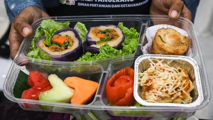 Dua peserta menyiapkan kreasi makanan bergizi saat Lomba Cipta Menu Makanan Pangan Beragam, Bergizi, Seimbang, dan Aman (B2SA) di Gedung Serbaguna, Kabupaten Tangerang, Banten, Selasa (23/7/2024). Dinas Pertanian dan Ketahanan Pangan Kabupaten Tangerang menyelenggarakan Lomba Cipta Makanan B2SA berbahan pangan lokal yang diikuti 28 perwakilan kecamatan untuk menciptakan menu makanan keluarga yang bergizi seimbang. ANTARA FOTO/Sulthony Hasanuddin/rwa.