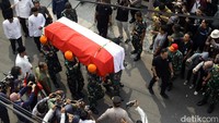 Enam prajurit TNI menggotong peti jenazah Hamzah Haz yang telah dibalut dengan bendera merah putih.  