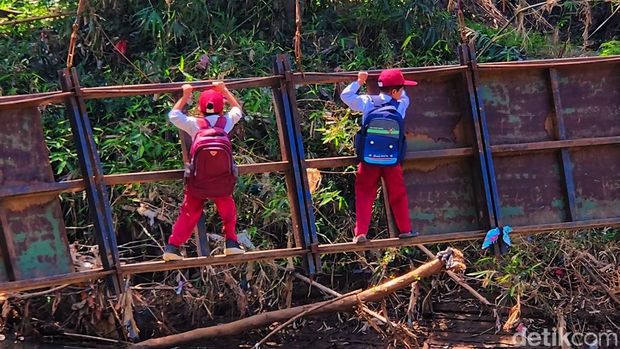 Pelajar meniti jembatan miring di Sukabumi.