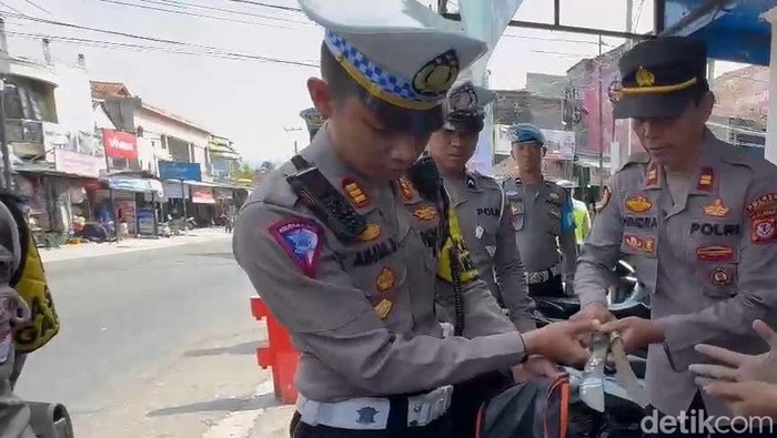 Polisi saat membongkar tas pelajar SMK di Cianjur