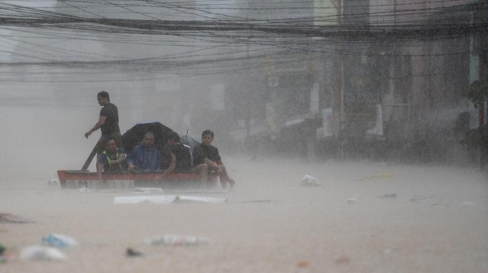Men wade through a flooded road following heavy rains brought by Typhoon Gaemi, in Manila, Philippines, July 24, 2024. REUTERS/Lisa Marie David