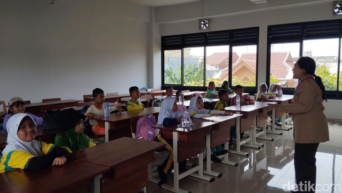 Siswa SDN Pondok Bambu 01 belajar di SDN Pondok Bambu 07. Jam belajar dimulai siang hari.