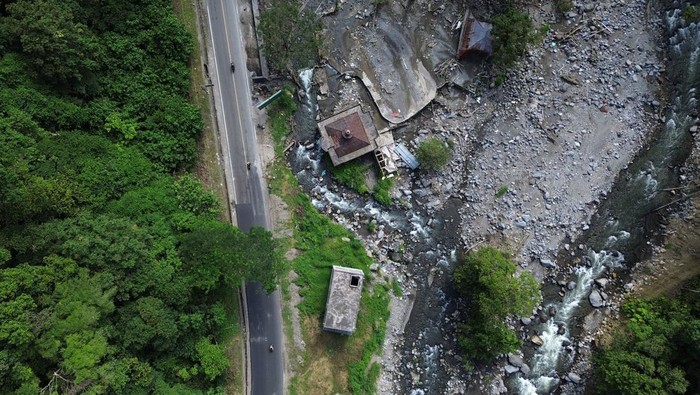 Tidak Boleh Lagi Ada Bangunan di Sempadan Sungai Lembah Anai Foto udara konstruksi bangunan hotel dan sebuah masjid berada di sempadan sungai yang rawan bencana, di kawasan Lembah Anai, Tanah Datar, Sumatera Barat, Rabu (24/7/2024). Pemerintah Provinsi Sumatera Barat mengeluarkan kebijakan melarang pendirian bangunan di di daerah aliran sungai (DAS) sekitar kawasan Lembah Anai yang terdampak banjir bandang 11 Mei 2024 lalu karena berbahaya. ANTARA FOTO/Iggoy el Fitra/foc.