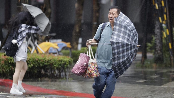 Topan Gaemi yang disertai hujan deras terjadi di Taipei, Taiwan. Angin topan tersebut membuat warga kewalahan saat berada di luar rumah.
