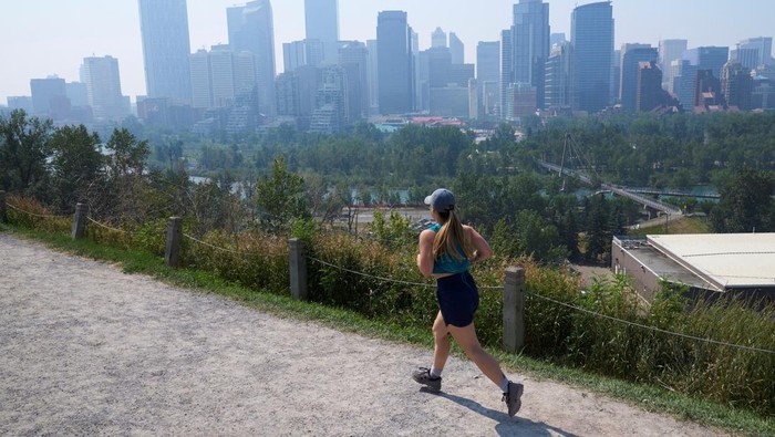 Asap Kebakaran Hutan Bikin Kualitas Udara di Kanada Memburuk A person jogs as the smoke from wildfires in British Columbia and Alberta blankets the downtown core of Calgary, Alberta, Canada July 24, 2024. REUTERS/Todd Korol