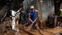 Endapan lumpur tebal menumpuk di jalan-jalan dan rumah warga.  