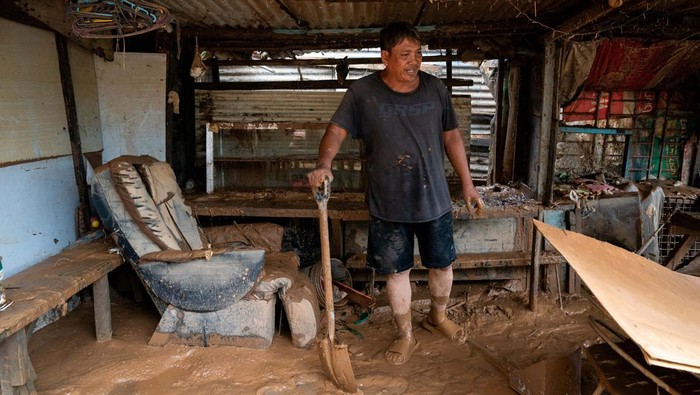 A man rests from cleaning mud from his house following the floods brought by Typhoon Gaemi, in San Mateo town, Rizal province, Philippines, July 25, 2024. REUTERS/Lisa Marie David