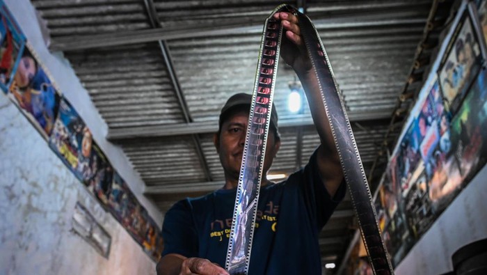 Jasa penyewaan film seluloid layar tancap di Tangsel Penyedia jasa penyewaan film untuk layar tancap, Nur Iyan, melakukan perawatan koleksi film seluloid 35mm di Nur Iyan Film, Pamulang, Tangerang Selatan, Banten, Kamis (25/7/2024). Pelaku usaha tersebut memiliki 450 koleksi judul film seluloid 35mm sejak tahun 1976 yang disewakan seharga Rp100 ribu sampai Rp500 ribu per judul tegantung film. ANTARA FOTO/Sulthony Hasanuddin/aww.