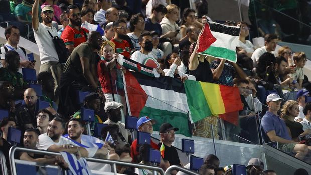 Spectators hold Palestinian flags as they watch the men's group D match between Israel and Mali at the Parc des Princes during the 2024 Summer Olympics, Wednesday, July 24, 2024, in Paris, France. (AP Photo/Aurelien Morissard)