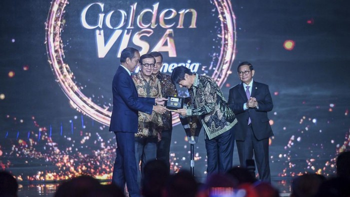 Presiden Joko Widodo (kiri) memberikan Golden Visa kepada Pelatih Sepak Bola Tim Nasional Indonesia Shin Tae-yong (keempat kiri) disaksikan oleh Menkum HAM Yasonna Laoly (kedua kiri), Dirjen Imigrasi Kemenkumham Silmy Karim (ketiga kiri), Sekretaris Kabinet Pramono Anung (ketiga kanan), Menko Marves Luhut Binsar Pandjaitan (kedua kanan), dan Menkopolhukam Hadi Tjahjanto (kanan) dalam acara peluncuran Golden Visa di Jakarta, Kamis (25/7/2024). Presiden mengatakan layanan Golden Visa diharapkan dapat memberi kemudahan bagi warga negara asing (WNA) dalam berinvestasi dan berkarya di Indonesia yang menargetkan investor dan pebisnis internasional, talenta global, dan wisatawan mancanegara yang memenuhi kriteria. ANTARA FOTO/Erlangga Bregas Prakoso/rwa.