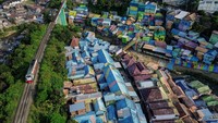 Foto udara kereta melintas di dekat kawasan Kampung Warna-Warni Jodipan (KWJ) di Malang, Jawa Timur, Jumat (26/7/2024).