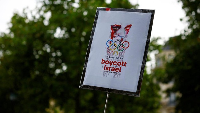 A protester holds a placard which reads 