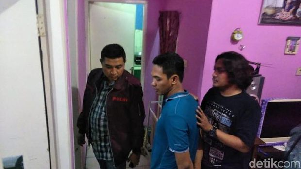Kapolres Gresik saat itu, AKBP Wahyu Bintoro bersama Lutfi (baju biru) pelaku pembunuhan istrinya usai menyerahkan diri dikeler ke TKP rumahnya