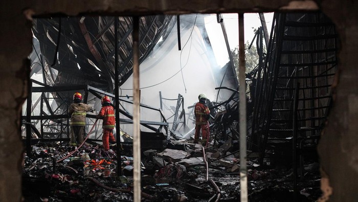 Kebakaran gudang alat tulis kantor di SurabayaGudang ATK di Surabaya Hangus Terbakar Sejumlah petugas Dinas Pemadam Kebakaran dan Penyelamatan (DPKP) Kota Surabaya melakukan pembasahan gudang di Jalan Raya Raci, Surabaya, Jawa Timur, Jumat (26/7/2024). DPKP mengerahkan sebanyak 23 kendaraan pemadam kebakaran untuk menjinakkan api yang menghanguskan gudang penyimpanan alat tulis kantor (ATK) dan berbagai jenis kertas. ANTARA FOTO/Didik Suhartono/rwa.