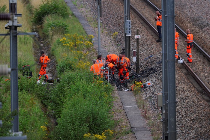 SNCF railway workers and law enforcement officers walk at the site where vandals targeted Frances high-speed train network with a series of coordinated actions that brought major disruption, ahead of the Paris 2024 Olympics opening ceremony, in Croisilles, northern France  July 26, 2024. REUTERS/Brian Snyder REFILE - CORRECTING FROM POLICE OFFICERS TO LAW ENFORCEMENT OFFICERS  .