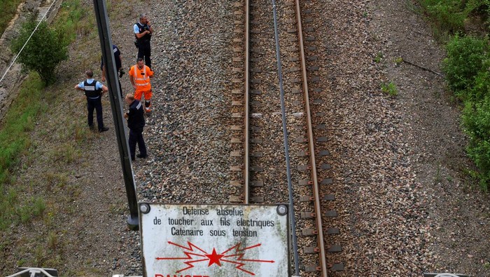Mayor of Vald?Yerre/Franck Marchand via Facebook via REUTERS SNCF railway workers and law enforcement officers walk at the site where vandals targeted France's high-speed train network with a series of coordinated actions that brought major disruption, ahead of the Paris 2024 Olympics opening ceremony, in Croisilles, northern France July 26, 2024. REUTERS/Brian Snyder REFILE - CORRECTING FROM 'POLICE OFFICERS' TO 'LAW ENFORCEMENT OFFICERS' .