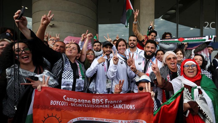 Palestinian athletes and pro-Palestinian supporters pose for a photo at the Charles de Gaulle airport ahead of the Paris 2024 Olympic Games, in Paris, France July 25, 2024. REUTERS/Yves Herman