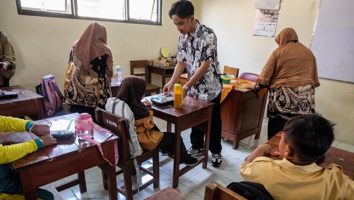 Wakil Presiden terpilih Gibran Rakabuming Raka (kiri) meninjau simulasi program makan bergizi gratis di SD Negeri Tugu, Solo, Jawa Tengah, Jumat (26/7/2024). Program makan bergizi gratis masuk dalam Rancangan Anggaran Pendapatan dan Belanja Negara (APBN) 2025 sebagai upaya pemerintah mempersiapkan generasi emas Indonesia sejak dini. ANTARAFOTO/Maulana Surya.