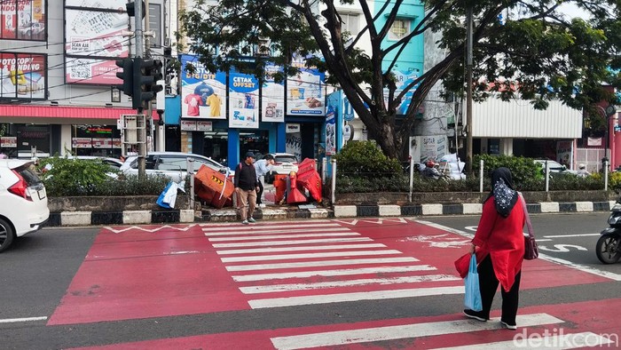 Pelican crossing di depan SDN Pocin 1, Jalan Margonda Raya, Depok tak ditutup secara permanen. Warga terlihat masih menyeberang di pelican crossing tersebut. (Maulana I Fawdi/detikcom)