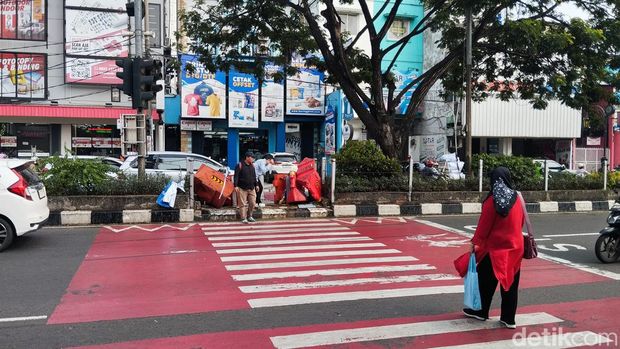 Pelican crossing di depan SDN Pocin 1, Jalan Margonda Raya, Depok tak ditutup secara permanen. Warga terlihat masih menyeberang di pelican crossing tersebut. (Maulana I Fawdi/detikcom)