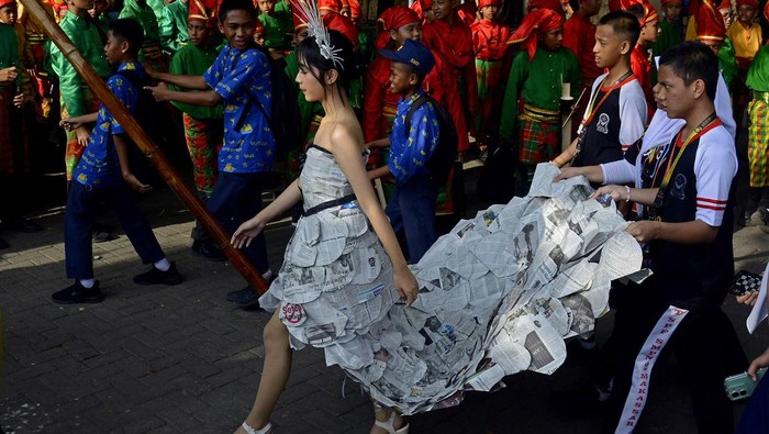Pemanfaatan limbah kertas koran menjadi busana Pelajar dari SMP Negeri 2 Makassar mengenakan busana hasil daur ulang kertas koran saat mengikuti karnaval budaya Makassar International Eight Festival and Forum (F8) 2024 di Anjungan Pantai Losari, Makassar, Sulawesi Selatan, Kamis (25/7/2024). Penggunaan koran bekas sebagai bahan busana tidak hanya membantu mengurangi jumlah limbah kertas yang masuk ke tempat pembuangan akhir, tetapi juga menekankan kreativitas siswa yang peduli dan bertanggung jawab terhadap lingkungan. ANTARA FOTO/Hasrul Said/YU/Spt.