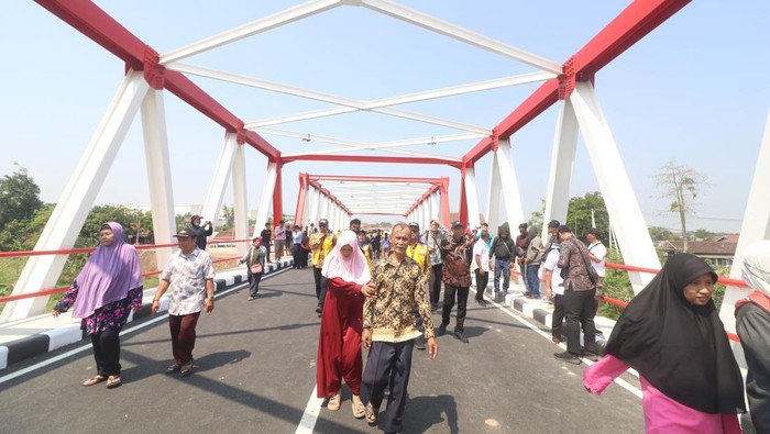 Warga berjalan kaki melewati Jembatan Jongbiru yang dibangun di atas Sungai Brantas saat peresmian di Kediri, Jawa Timur, Jumat (26/7/2024). Jembatan Jongbiru yang dibangun dengan anggaran Rp27 miliar dari APBN tahun 2023-2024 tersebut guna mendukung akses kendaraan menuju Bandara Dhoho sekaligus penghubung antara kota dengan kabupaten Kediri. ANTARA FOTO/Prasetia Fauzani/tom.