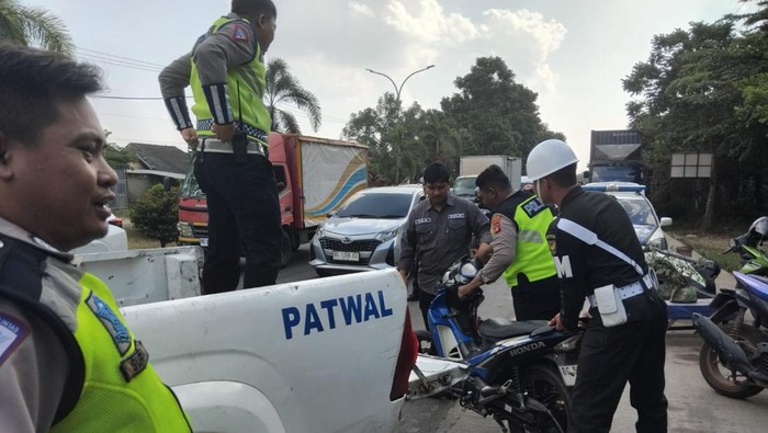 Polisi bersama PM saat mengevakuasi motor anggota TNI AD yang tabrak Pajero