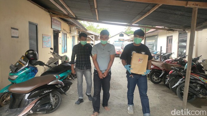 Polisi saat mengamankan pria bernama Kaharuddin (tengah) yang menganiaya pacarnya di Polman.