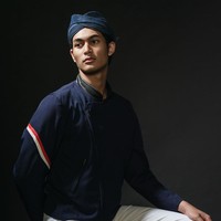 Material yang menyerupai denim untuk beskap memberikan kesan modern, ditambah lagi dengan kehadiran garis merah-putih sebagai aksentuasi asimetris di lengan kanan. Tidak ketinggalan aksesori tambahan berupa blangkon kulit hitam dan selop senada yang menciptakan kesan edgy pada penampilan para pria. (Foto: Dok. Davy Linggar)