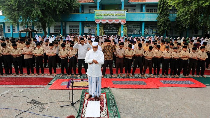 Sejumlah siswa siswi bersama dewan guru melaksanakan shalat minta hujan atau Shalat Istisqa di halaman Madrasah Tsanawiyah Swasta (MTsS) Harapan Bangsa Desa Kuta Padang, Johan Pahlawan, Aceh Barat, Aceh, Jumat (26/7/2024). Shalat tersebut dilaksanakan untuk meminta kepada Allah SWT menurunkan hujan sehingga kekeringan dan kesulitan air akibat musim kemarau segera berakhir. ANTARA FOTO/Syifa Yulinnas/rwa.