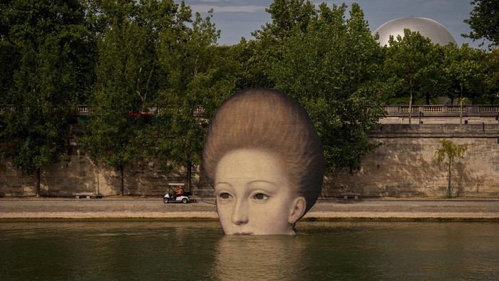Sungai Seine Jadi Saksi Sejarah Baru Olimpiade A technician drives in a cart by reproductions of artworks decorating the banks of the River Seine, the day before the opening ceremony of the 2024 Summer Olympics, Thursday, July 25, 2024, in Paris, France. (AP Photo/Vadim Ghirda)