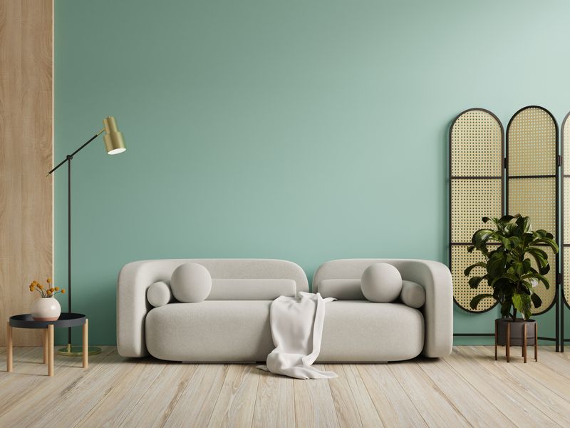 Wall mockup in green color with gray sofa and decor in living room.3d rendering