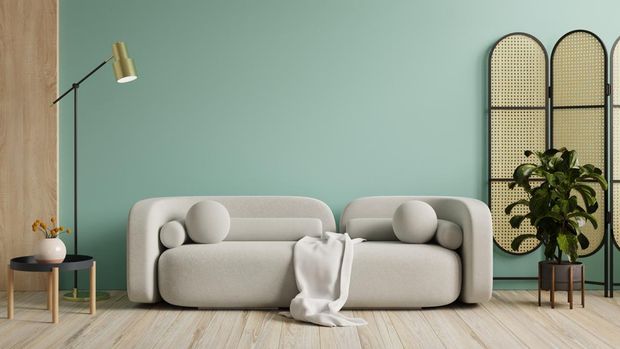 Wall mockup in green color with gray sofa and decor in living room.3d rendering