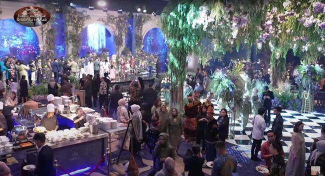 Tak kalah mencuri atensi, dekorasi di acara resepsi Thariq dan Aaliyah itu juga tampak begitu mewah bak berada di taman khayalan yang indah. Dipenuhi dengan beragam bunga dan tumbuhan hijau membuat dekorasi pernikahan tersebut terlihat hidup dan asri. Foto: YouTube/Thariq Halilintar