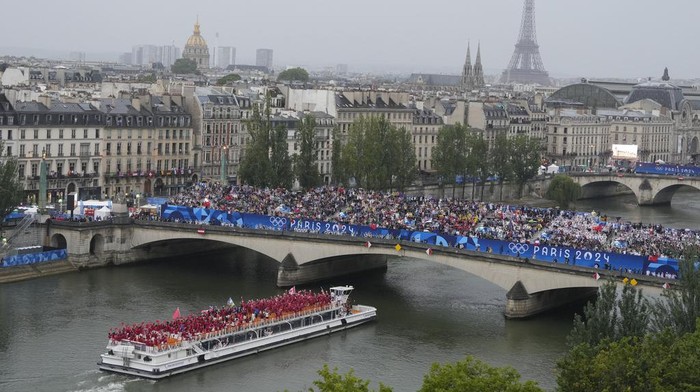 Athletes travel by boat along the Seine River during the opening ceremony of the 2024 Summer Olympics, in Paris, France, Friday, July 26, 2024. (AP Photo/Ricardo Mazalan)