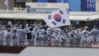 Tampak kontingen Korea Selatan memakai jas hujan saat parade atlet di atas kapal. AP/Ariana Cubillos