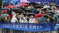 Penonton di sepanjang tepi Sungai Seine pun tetap antusias menyaksikan pembukaan Olimpiade Paris 2024 meski diguyur hujan deras. AP/John MacDougall