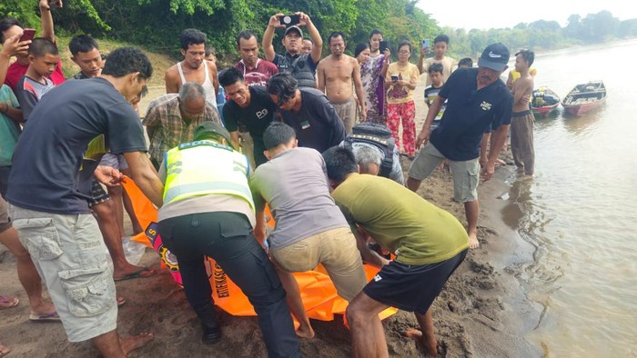 Polisi saat melakukan evakuasi jenazah korban yang ditemukan mengapung di Sungai Musi