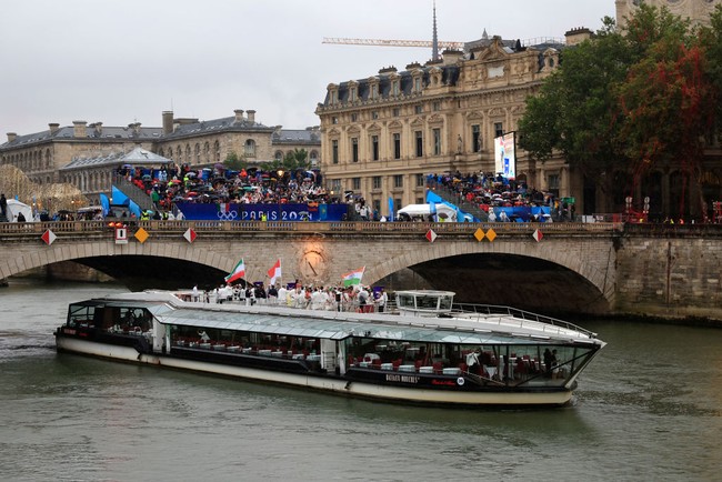 Untuk pertama kalinya dalam sejarah, acara pembukaan pesta olahraga empat tahunan ini digelar di luar stadion. Di Olimpiade musim panas yang diikuti 206 negara ini, perwakilan kontingen berarak-arakan sembari menelusuri Sungai Seine yang tersohor itu dengan kapal. Hujan tak mengurangi antusias mereka untuk ambil bagian dalam perhelatan yang disaksikan miliaran pasang mata di seluruh dunia itu. (Foto: Getty Images/Buda Mendes)