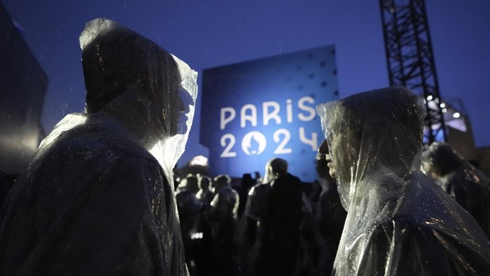Musicians wait in the rain before performing, in Paris, France, during the opening ceremony of the 2024 Summer Olympics, Friday, July 26, 2024. (AP Photo/Robert F. Bukaty)