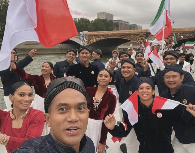 Material denim untuk beskap memberikan kesan modern, ditambah lagi dengan kehadiran garis merah-putih sebagai aksentuasi asimetris di lengan kanan. Tidak ketinggalan aksesori tambahan berupa blangkon dan selop senada yang menciptakan kesan edgy pada penampilan para pria. (Foto: Instagram/@andiyabakrie)