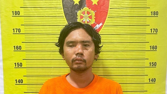 Tampang pelaku IG alias Lajur saat diamankan di kantor polisi.